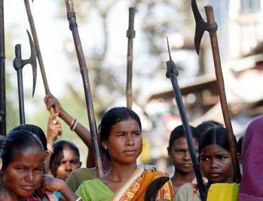 Mujeres de las tribus adivasis, los más pobres de la India, empuñando armas en la guerra popular